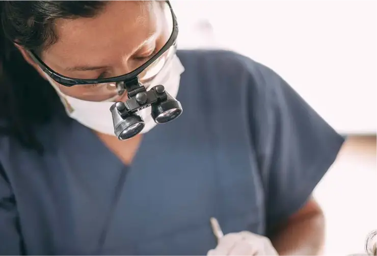 Zahnärztin bei einer endodontischen Behandlung mit Vergrößerungslupe in der Zahnarztpraxis Sandhofpassage Frankfurt – präzise Wurzelkanalbehandlung für Zahnerhaltung