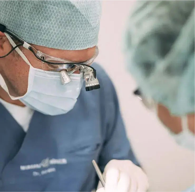 Zahnarzt bei einer endodontischen Behandlung mit Vergrößerungslupe in der Zahnarztpraxis Sandhofpassage Frankfurt – präzise Wurzelkanalbehandlung für optimale Zahnerhaltung