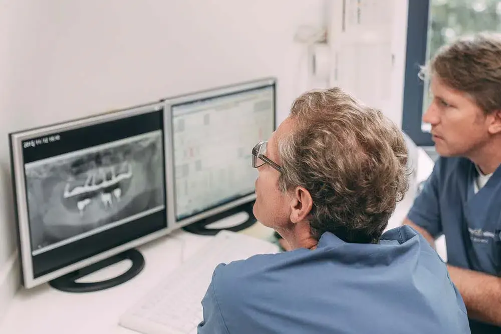 Zahnärzte bei der Analyse von Röntgenbildern in der Zahnarztpraxis Sandhofpassage Frankfurt – präzise Diagnose und Behandlungsplanung für Zahngesundheit